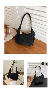 Black fringed bag with a gold heart charm shown on a table and carried by hand from several angles