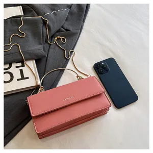 Platte weergave van een roze tas met klep, ringgreep en goudkleurige ketting als schouderband