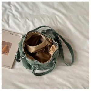 Vue intérieure du sac vert ouvert, doublure brune satinée, poches et fermeture zippée argentée