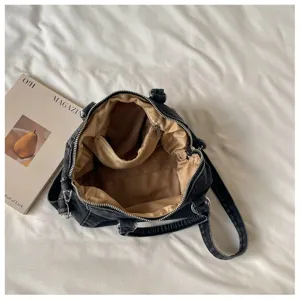 Vue de dessus sur la fermeture éclair ouverte, la doublure beige et les compartiments intérieurs du sac