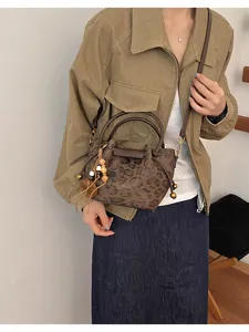 Sac porté en bandoulière, motif léopard, anses brun foncé, perles en bois et pompon décoratif