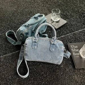 Sac Boston en denim bleu délavé, avec poignées, bandoulière amovible et zip argenté