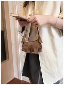 Brown suede-look fringed bag with a gold heart charm, shown hanging from its slim strap