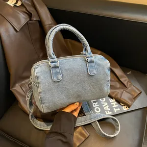 Sac Boston en denim bleu clair délavé, avec anses, fermeture zippée et bandoulière amovible