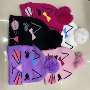 Flat lay of five colorful knit hats with cat faces, bows, whiskers and fluffy pom-poms