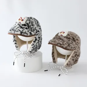 Deux bonnets doux à oreilles, motif léopard, patchs cartoon, bord brun et liens tressés blancs