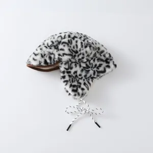 Vue à plat d'un bonnet en peluche à motif léopard, avec bordure brune et liens tressés blancs