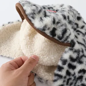 Gros plan sur la doublure blanche effet mouton, le tissu tacheté et le bord brun du bonnet
