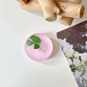 Close-up van een matroze rond oppervlak met een groen klavermotief, gestyled op een wit tafelblad