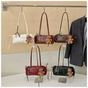Cinque piccole borse in vari colori, con stelle decorative e ciondoli a forma di orsetto