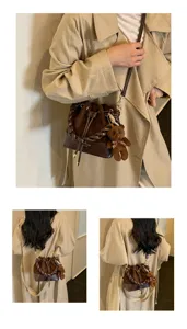 Close-up views of a brown bucket bag worn crossbody, with braided handle, teddy charm and scarf