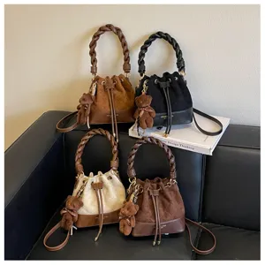 Four suede-look bucket bags in mixed colors, with braided handles, drawstring tops and bear charms