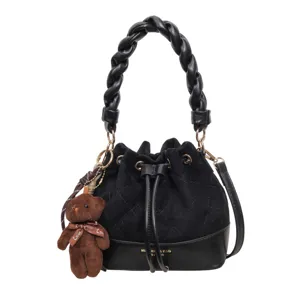 Black bucket bag with quilted suede panels, braided handle, gold hardware and teddy bear charm