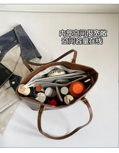 Vue plongeante sur un sac marron ouvert, avec rangements spacieux pour cosmétiques et petits objets
