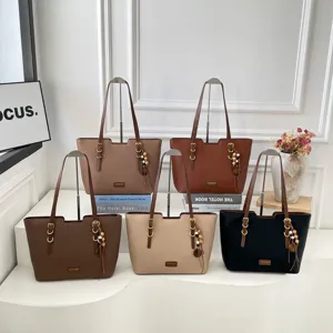 Cinq cabas effet cuir bruns, camel, beige et noir, avec détails dorés et perles de bois décoratives