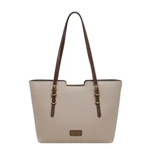 Sac beige à texture grainée, anses brun foncé, boucles dorées et plaque métallique sur fond blanc