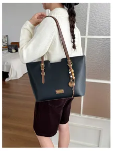 Vue arrière d’une femme avec un cabas noir, une bandoulière marron et un pendentif en perles de bois