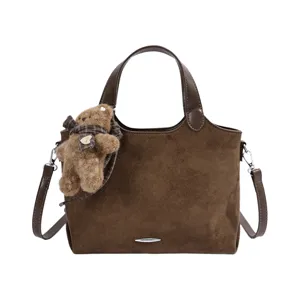 Bruine suèdelook tas met pluchen berenhanger, geruite strik, schouderriem en metalen detail