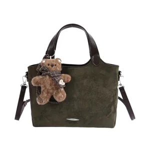 Vintage groene suède-look shopper met bruine leren handvatten en een schattige teddybeerhanger
