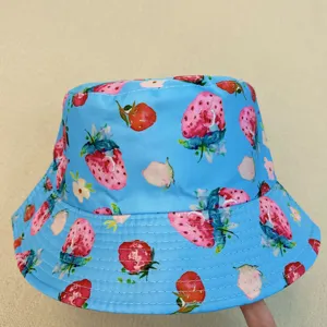 Close-up of a blue hat with strawberry, flower and leaf prints and rows of stitching on the brim