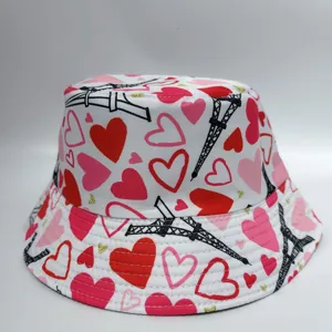 Close-up of a white bucket hat covered in red and pink hearts with black Eiffel Tower prints