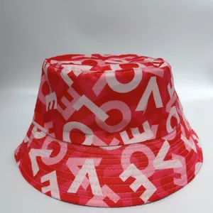 Red and pink fabric hat with bold white letter-style geometric print and double-stitched brim