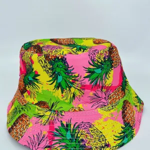 Close-up of a vivid pineapple-print hat in pink, yellow and green, with a stitched brim