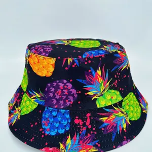 Front view of a black bucket hat with vivid pineapple and berry prints on a clean white background
