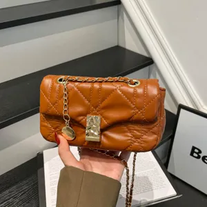 Piccola borsa a tracolla marrone trapuntata a rombi, con catena dorata, chiusura e ciondolo