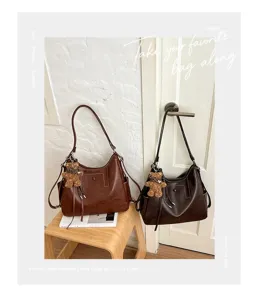 Two brown faux-leather shoulder bags with teddy charms, shown with adjustable straps in a room
