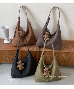 Quatre sacs tissés à bandoulière, bruns, taupe, noirs et kaki, avec un pendentif ourson chacun
