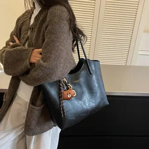 Große schwarze Shopper-Tasche aus Kunstleder mit Schulterriemen und kleinem Teddybär-Anhänger
