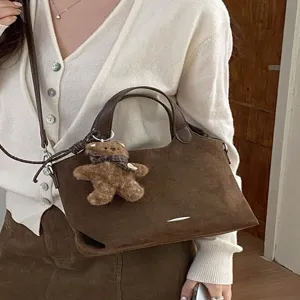 Brown suede-look tote handbag with top handles, shoulder strap, silver accent and teddy bear charm