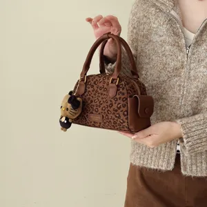 Sac Boston brun à imprimé léopard, poignées arrondies, finitions dorées et breloque peluche