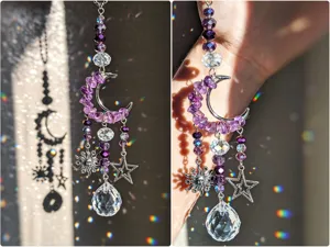 Dettaglio di perline viola, ciondoli a luna, sole e stella, con una goccia di cristallo sfaccettato
