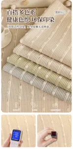 Close-up of layered striped jacquard sofa fabrics in beige, green and blue-gray with raised dots