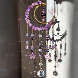 Close-up of purple crystal beads, enamel flowers and hanging faceted prisms on a gold crescent