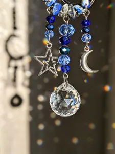Primo piano di lapislazzuli, perline di vetro blu, ciondoli a stella e mezzaluna, sfera cristallina