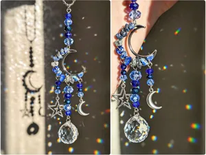 Primo piano di perline blu, mezzaluna e stelle argentate, con una sfera di cristallo trasparente