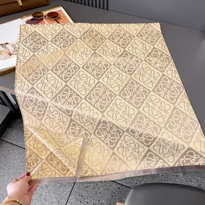 Flach ausgelegter Jacquard-Schal in Beige und Taupe mit geometrischem Muster und Fransenkante