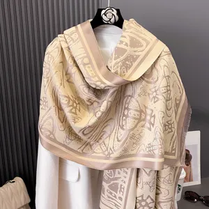 Beige-braun gemustertes Tuch mit Fransen, über einem weißen Mantel am Bügel drapiert