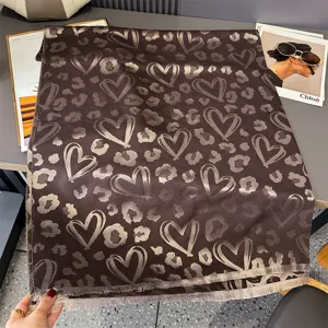 Sciarpa marrone distesa, con cuori chiari, stampa leopardata e bordi rifiniti con frange