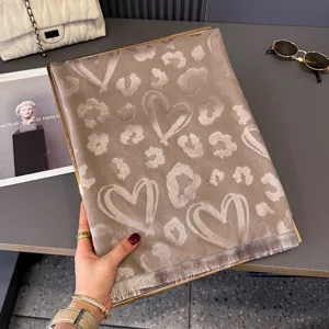 Sciarpa taupe in jacquard con macchie leopardate, cuori disegnati e frange alle estremità