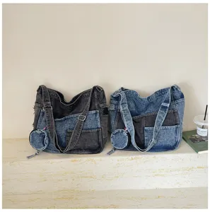 Two washed denim bags in charcoal and light blue, with patchwork panels and round coin pouches