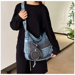 Model wearing a patchwork denim shoulder bag with a wide strap, pockets and round coin purse