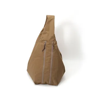 Detail einer braunen Nylontasche mit dreieckiger Form und zwei senkrechten Frontreißverschlüssen