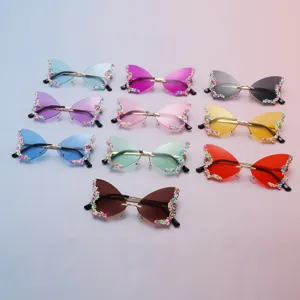 Dix lunettes papillon sans monture, aux verres colorés et bords perlés sur un fond pastel