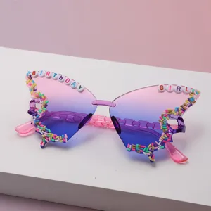 Close-up of rimless butterfly sunglasses with pink-purple gradient lenses and birthday letter beads