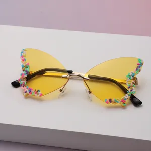 Lunettes papillon sans monture, verres jaunes, bords perlés colorés et branches noir et or