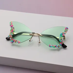 Lunettes papillon sans monture, verres verts et décorations colorées en perles sur les bords